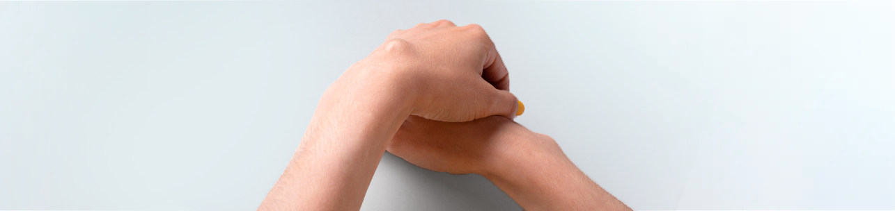 Braço e mão estendidos com um lipoma evidente na região do antebraço ou pulso, em fundo claro.