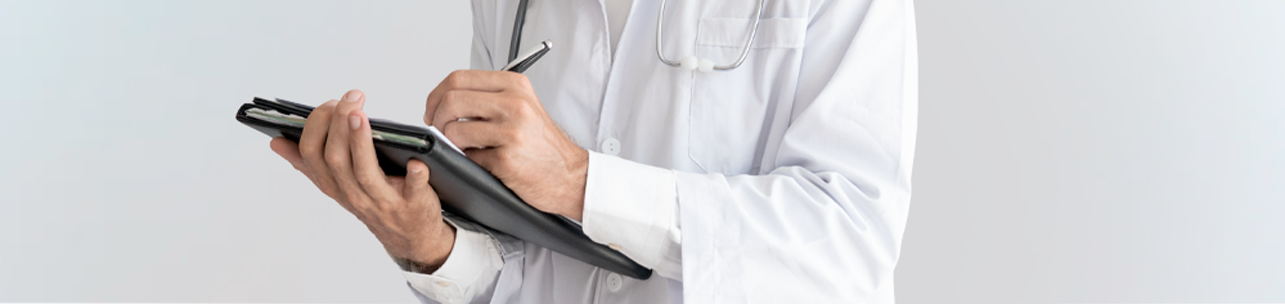 um médico vestindo jaleco branco e estetoscópio, escrevendo notas em uma prancheta ou pasta preta com uma caneta. O fundo é neutro e claro.